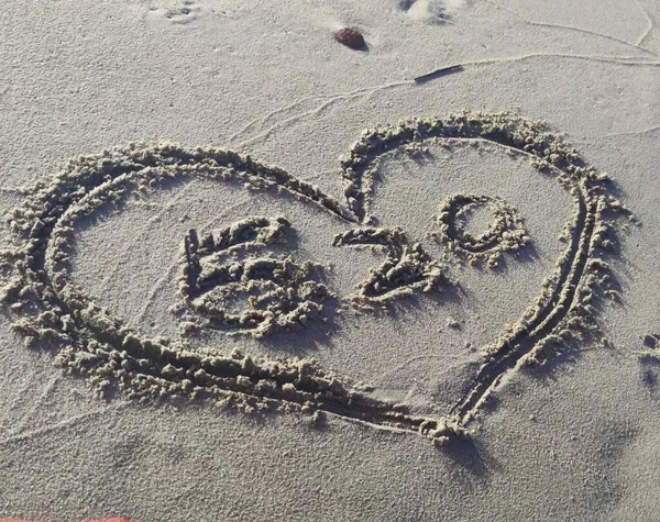 heart drawn in the sand on the beach