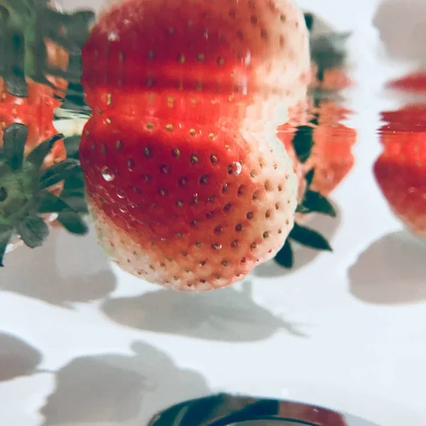 close up of a red and white strawberry