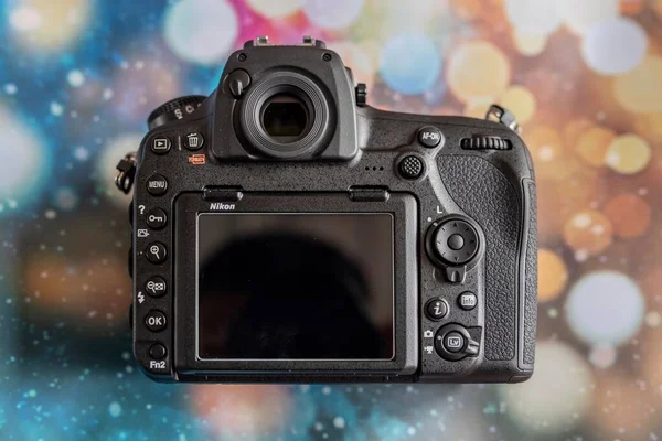 camera on a background of a red screen with a blurred bokeh.