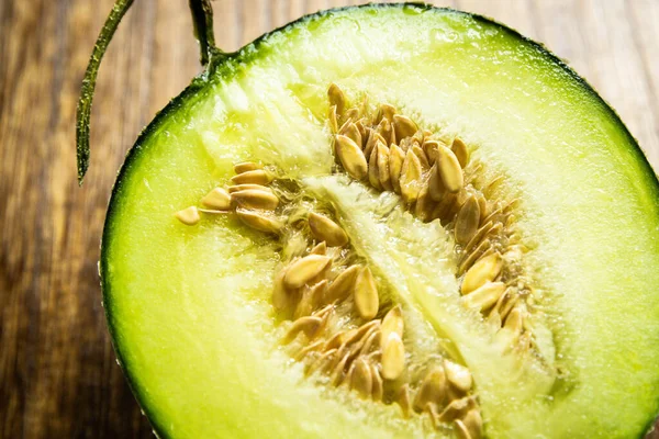 fresh ripe green melon on wooden background