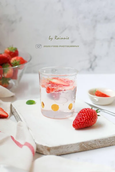 glass of strawberry juice with fresh strawberries and mint on white background