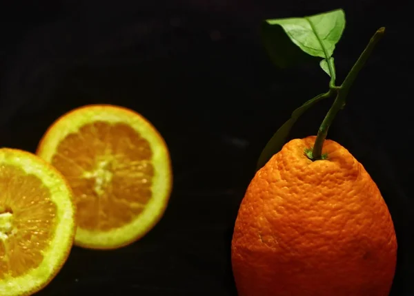 fresh orange and green leaves on black background