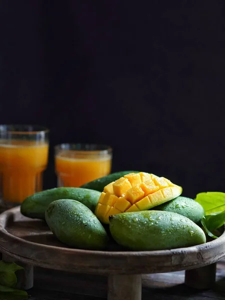 fresh mango juice in a glass bowl on a black background.
