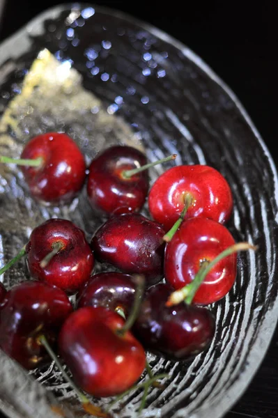 fresh ripe red cherries in a basket on a black background