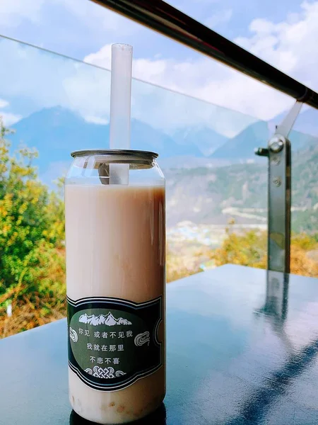 glass of milk and ice cubes on the background of the mountains.