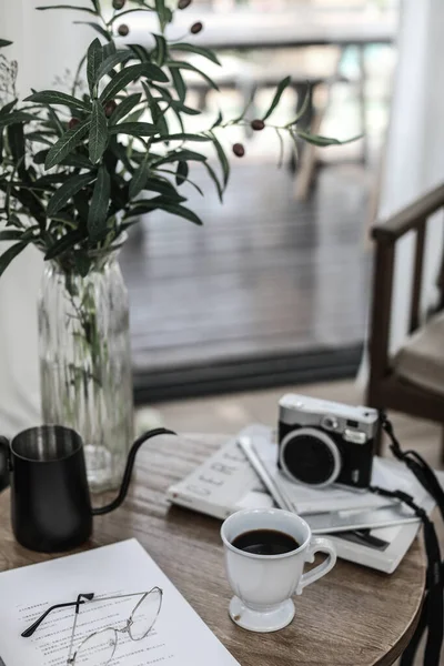vintage camera, cup of coffee and a book on a wooden table