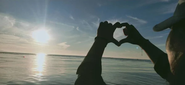 silhouette of couple holding hands on the beach