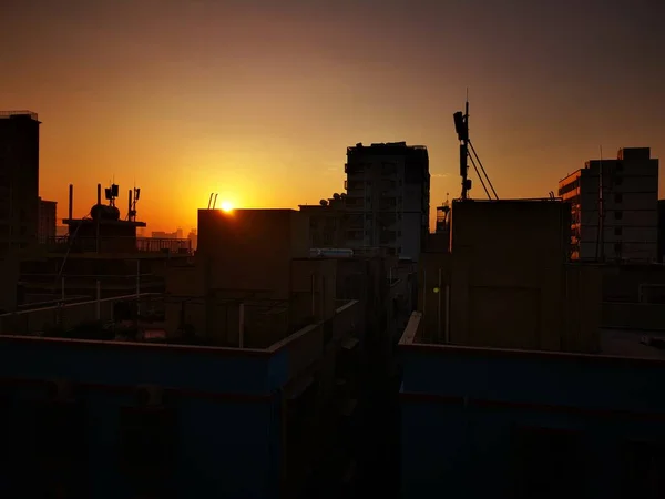 silhouette of a building with a crane and a city view