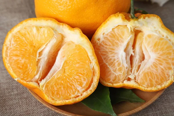 fresh ripe orange and slices of mandarin on wooden background