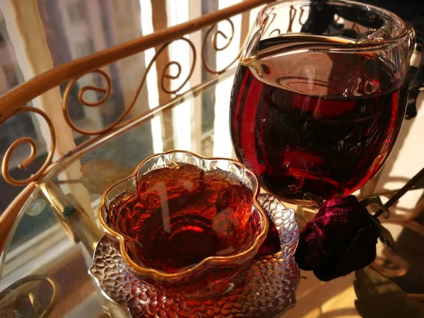 glass of red wine and a cup of tea on a wooden table