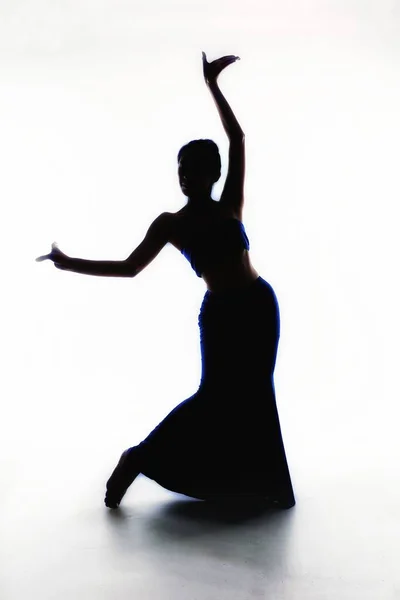silhouette of a ballerina in a black dress on a white background