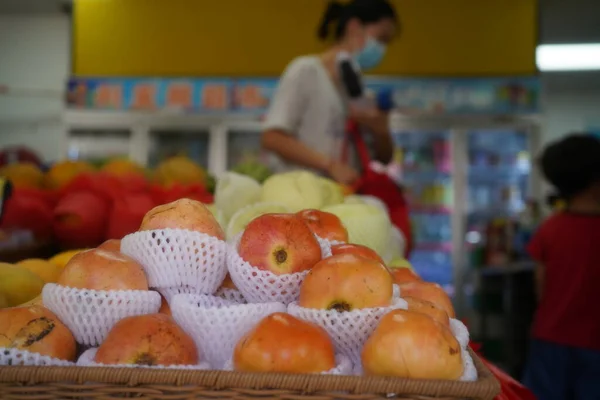 woman with a basket of fruits in the store