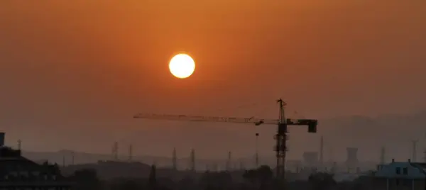 stock image silhouette of a construction cranes on the background of the setting sun