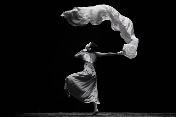 young man in black and white pack dancing on a dark background