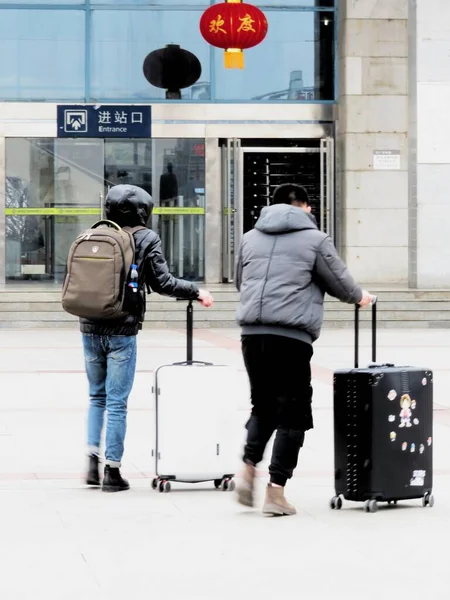man and woman walking with luggage in airport