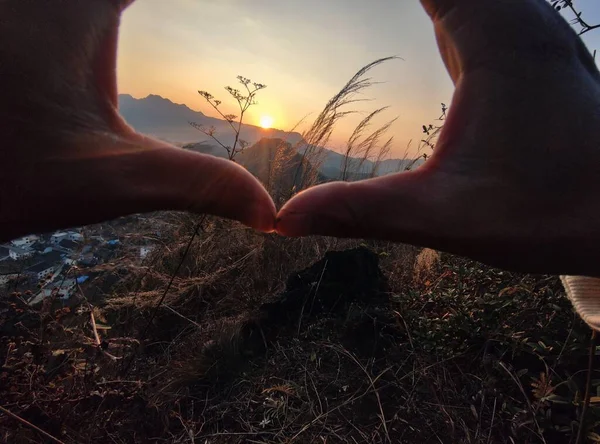 hands holding a heart in the sky