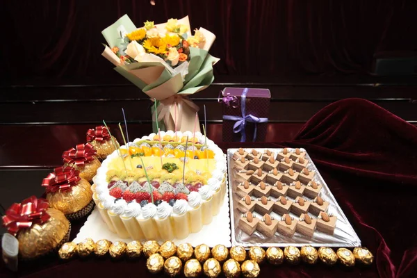 delicious cake with sweets and fruits