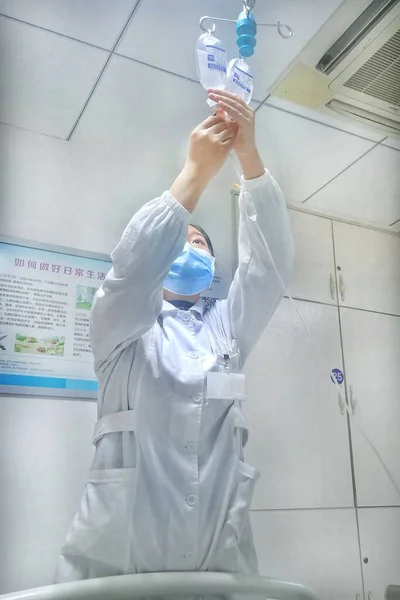 scientist in a protective uniform and a mask in a lab