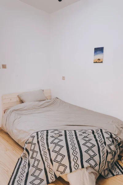 white bedroom with a pillow and a blanket