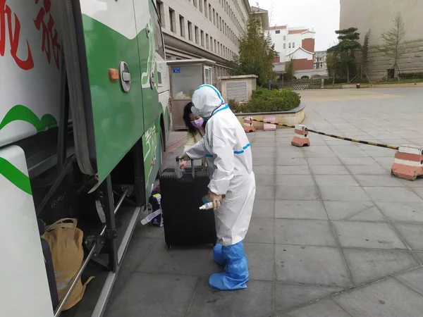 worker in protective uniform and mask with a vacuum cleaner