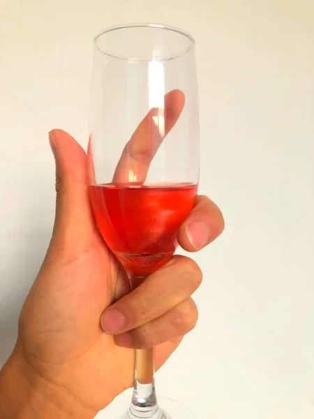 a glass of red wine with a white background