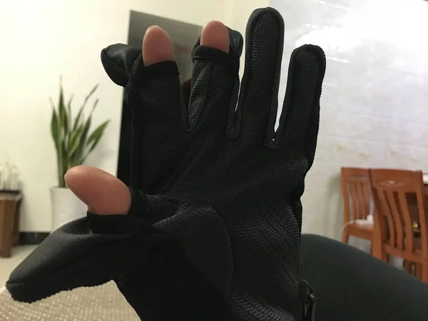 black leather gloves and a white glove on a gray background