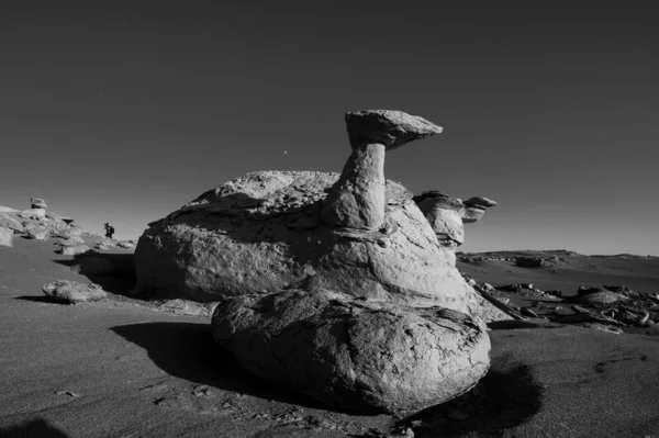 black and white photo of a rock formations in the desert