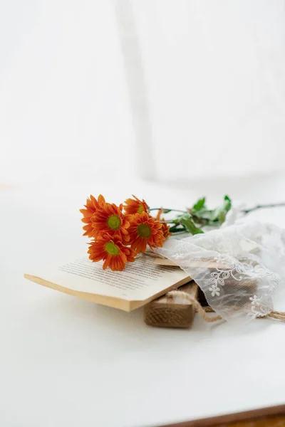 beautiful bouquet of flowers and a book on a white background