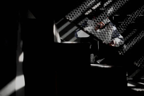 man in black suit and white shirt with a gun on a dark background