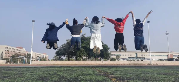 group of people jumping in the park