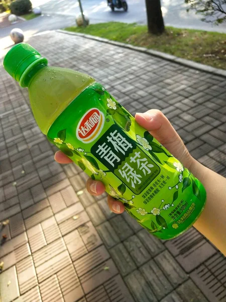 green plastic bottle with a glass of water
