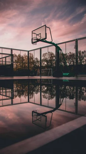 silhouette of a basketball court on the background of the sunset.