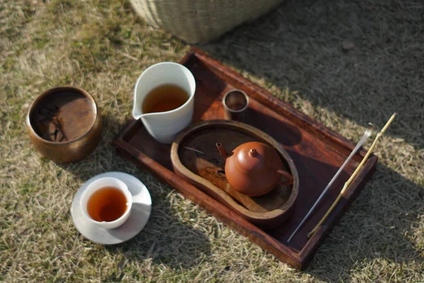 tea ceremony with green grass and a cup of coffee and a book on a wooden table