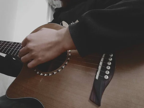close up of a male hand holding a guitar