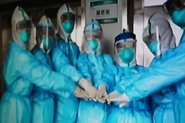 group of surgeons in protective masks standing in hospital corridor