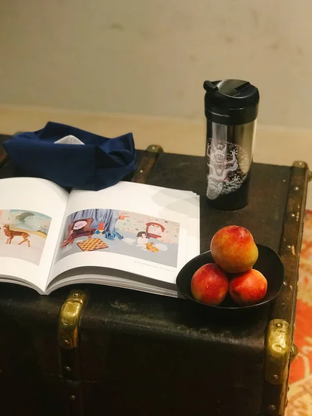 old book with a pencil and a bag of tea