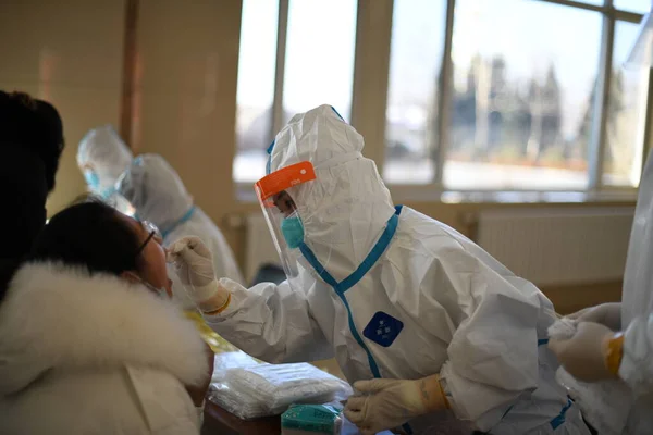 a group of people in a protective mask and gloves are standing in a hospital.
