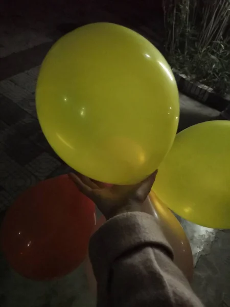 a man with a balloon in the hands of a boy