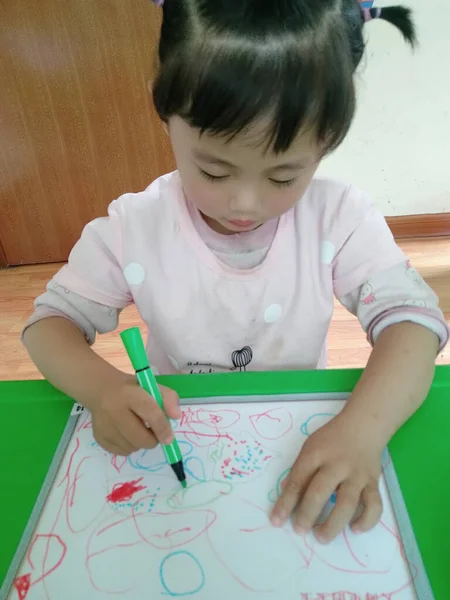 little girl drawing a book