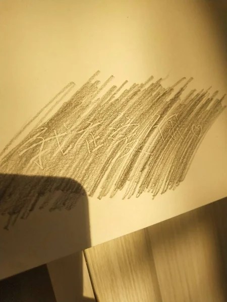 a closeup shot of a paper with a feather on a wooden background