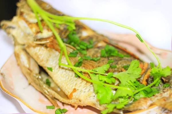 fried fish with vegetables and herbs