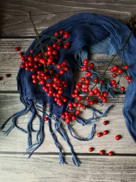autumn berries and rowan branches on a wooden background.