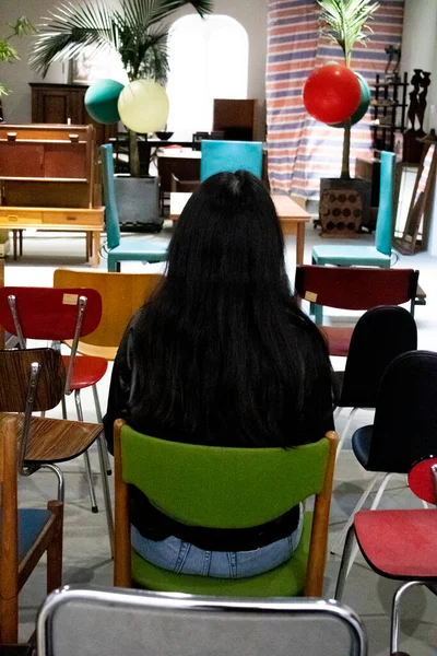 young woman sitting in a chair in a classroom