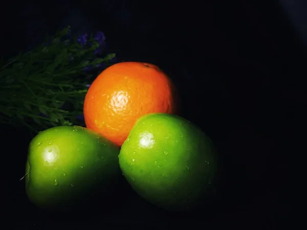 green and red apples on a black background