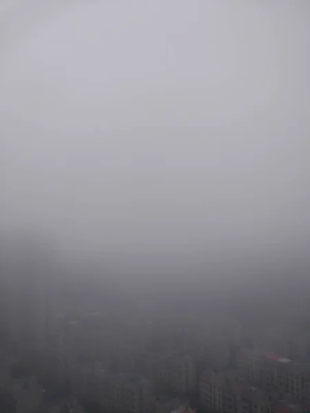 a vertical shot of a city with a fog