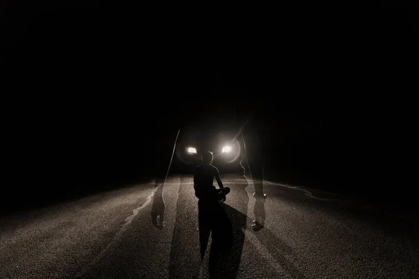 silhouette of a man in a black dress with a lantern on the background of the night sky