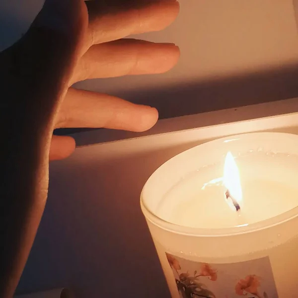 candle in the hands of a woman on a dark background