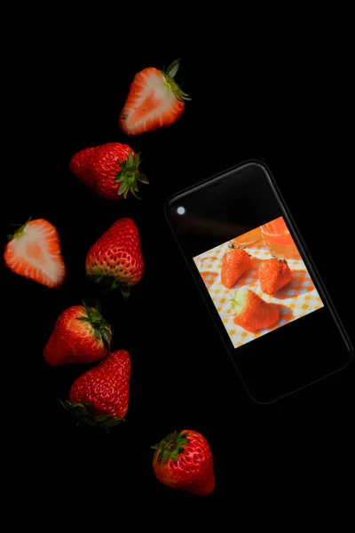 fresh strawberry and strawberries on black background