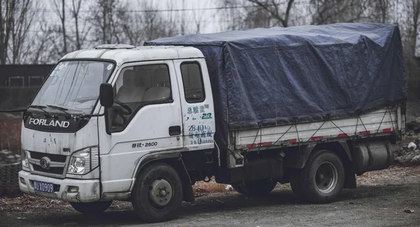 a small truck is parked in the forest