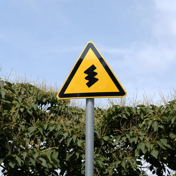 road sign with a warning symbol